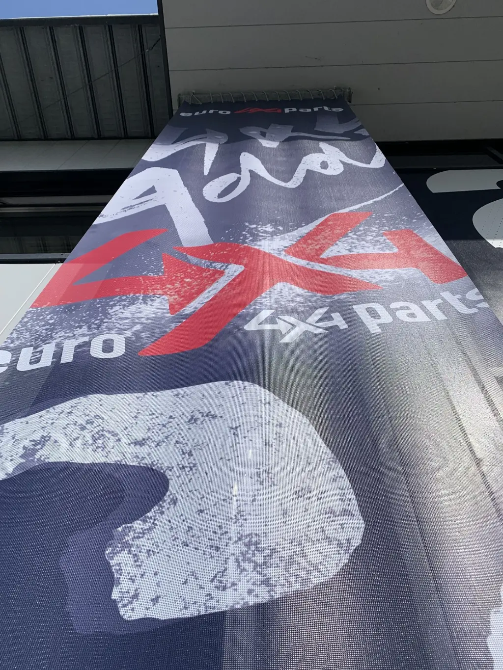 Bâche sur mesure grand format pour la devanture d’un magasin, visible de loin