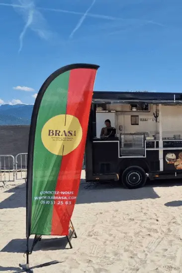 Oriflamme publicitaire personnalisée installée à côté d’un food truck